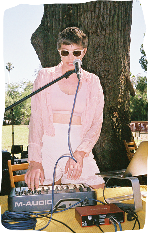 Musician in sunglasses performing on a keyboard controller at an outdoor event, representing Kyoto's ambient music scene.