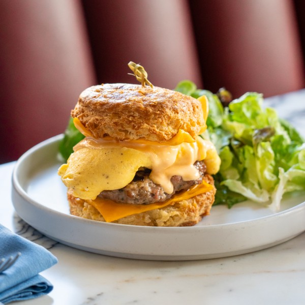 A plate with a cheese burger and salad